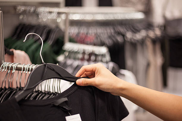 istock Woman's Hands Selecting Cloths in Fashion Store 494316118