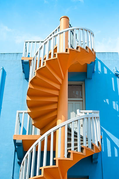 istock Yellow spiral staircase against blue wall 494316198