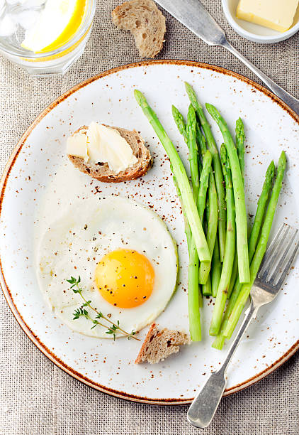 istock Green asparagus,fried egg and bread with butter. 494317694