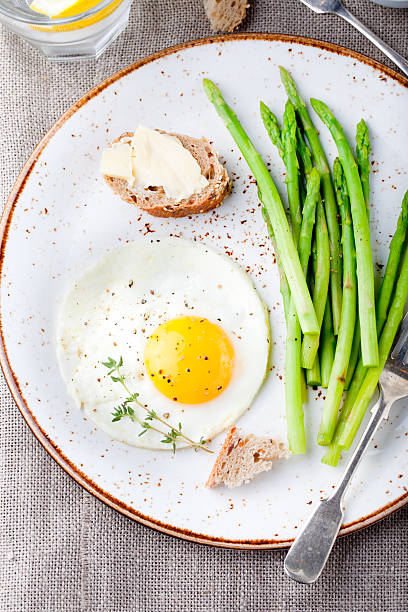 istock Green asparagus,fried egg and bread with butter. 494317734