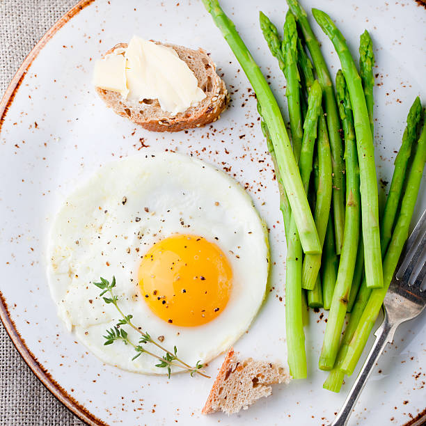 istock Green asparagus,fried egg and bread with butter. 494317804