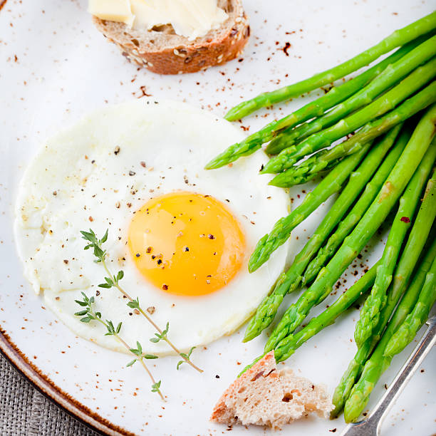 istock Green asparagus,fried egg and bread with butter. 494317994