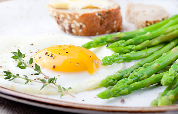 istock Green asparagus,fried egg and bread with butter. 494318132