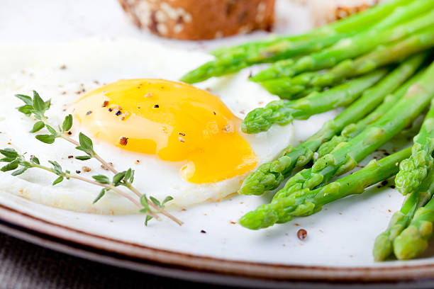 istock Green asparagus,fried egg and bread with butter. 494318158