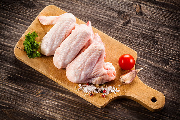 Raw chicken wings on cutting board stock photo