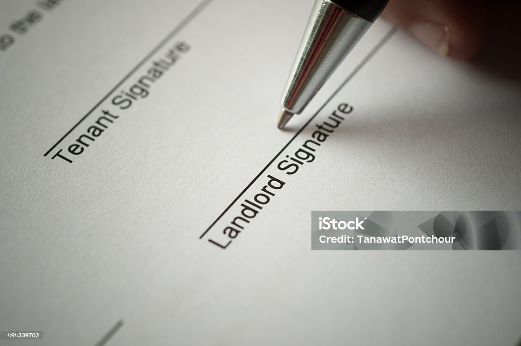 Rental agreement Rental agreement form with signing hand and pen. Landlord Stock Photo