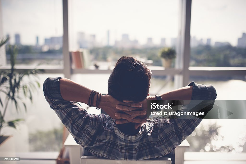 Moment of relaxation Man relaxing in his chair and enjoying the view from office window Relaxation Stock Photo