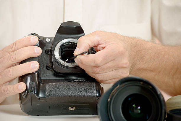istock photographer cleaning sensor of his camera 494342694