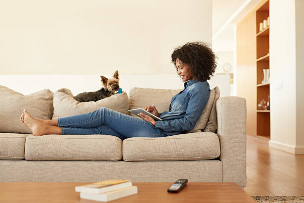 Getting to know her new tablet Shot of a young woman relaxing on the sofa with her digital tablet at homehttp://195.154.178.81/DATA/i_collage/pu/shoots/805808.jpg feet up stock pictures, royalty-free photos & images