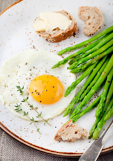 istock Green asparagus,fried egg and bread with butter. 494345698