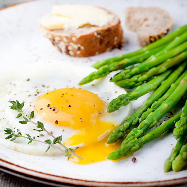 istock Green asparagus,fried egg and bread with butter. 494345826