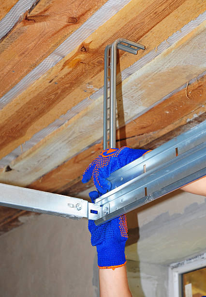 istock Contractor Installing Garage Door Metal Profil Post Rai tol Garage Ceiling. 494346214
