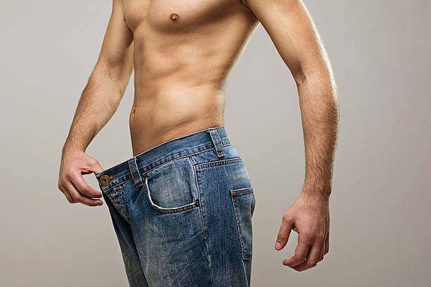 istock Muscular fit man wearing big jeans after diet 494346523