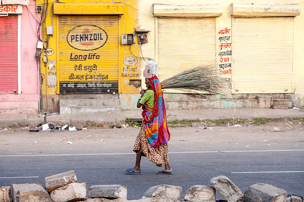 woman of fourt class in brightly colored clothing Jaipur, India - October 20, 2012: woman of fourt class in brightly colored clothing cleans the street in Jaipur, India. They earn 300 IRP for two hours paid by the government. rag picker stock pictures, royalty-free photos & images