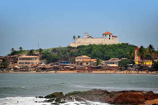 Elmina, Ghana, West Africa: beach and the hill top Sao Tiago fort, built by the Portuguese in 1555 and taken by the Dutch 82 years later becoming Fort Coenraadsburg / Conraadsburg, aka Fort Sao Jago da Mina - Feitoria da Mina, Gold Coast - Unesco world heritage site - photo by M.Torres