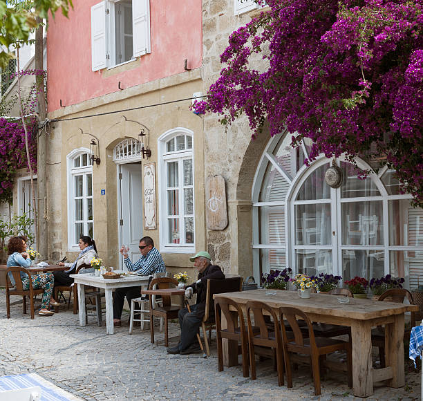 Izmir, Turkey - May 09, 2014:Turkish people in cafe.Turkish people sitting on chairs enjoying vacation in cafe.Alaçatı is an Aegean town on the western coast of İzmir Province in Turkey.Alacati is a popular place for Wind surfing.