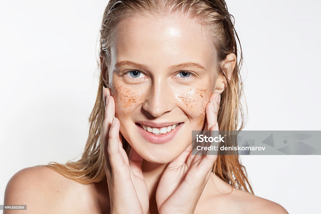 Woman cleans the skin coffee scrub Smiling woman cleans the skin coffee scrub Human Face Stock Photo