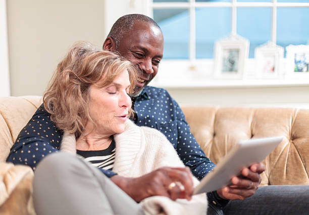istock Couple relaxing and looking at tablet computer 494352559