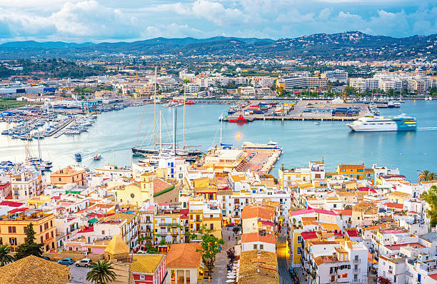 Ibiza - Elevated view over Ibiza Town and harbour Ibiza - Elevated view over Ibiza Town and harbour with an incoming ferry at dusk ibiza town stock pictures, royalty-free photos & images