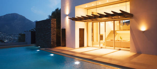 istock Illuminated modern house overlooking swimming pool 494358339