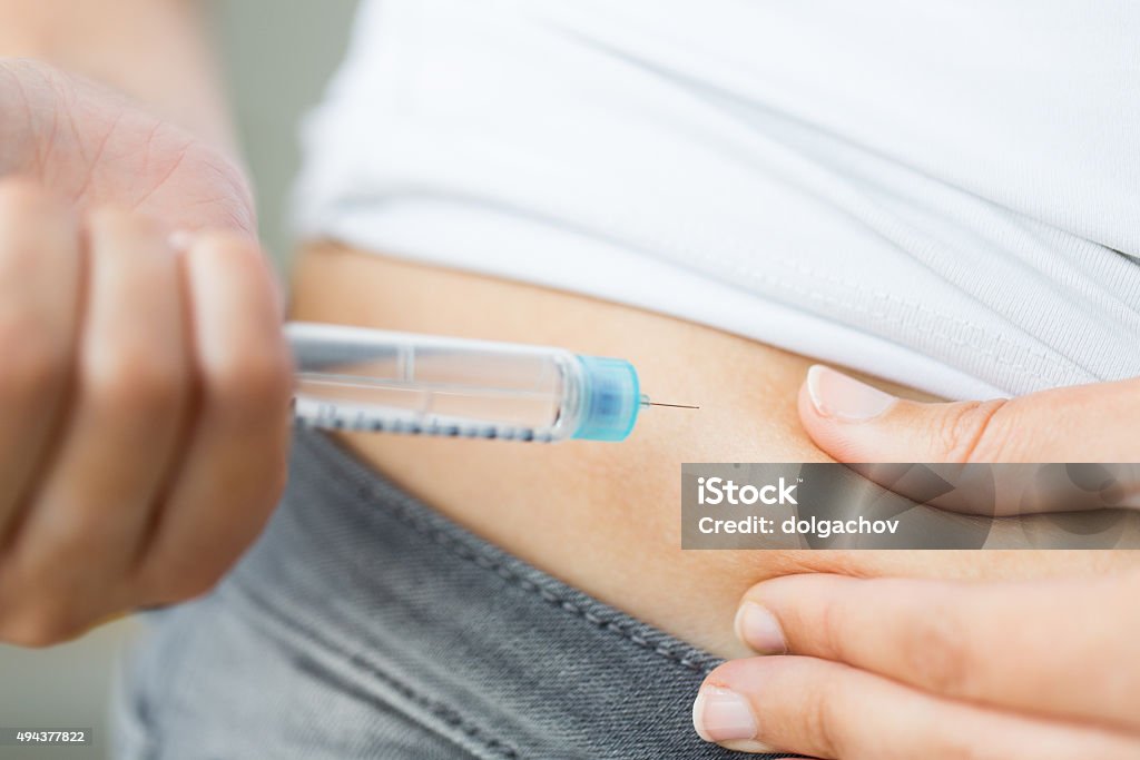 close up of hands making injection by insulin pen medicine, diabetes, glycemia, health care and people concept - close up of woman hands making injection with insulin pen or syringe Syringe Stock Photo