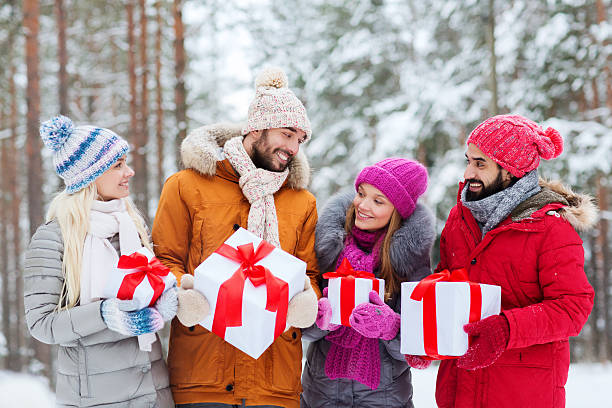 glückliche freunde mit geschenk-boxen auf winter-wald - gift new year couple men stock-fotos und bilder