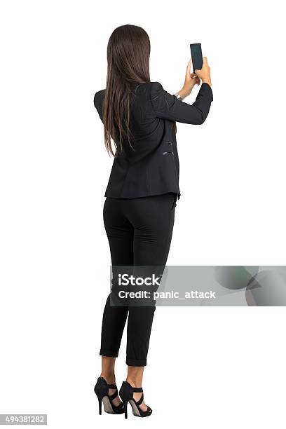 Rear View Of Woman In Suit Taking Photo With Cellphone Stock Photo - Download Image Now