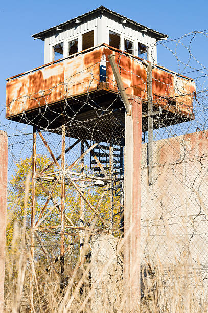 istock Abandoned watch-tower and prison fence wire barbs 494383274