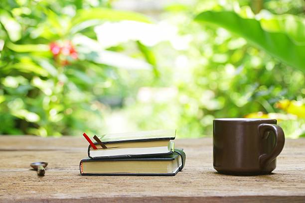 istock Notebook  and coffee in brown cup on wooden table 494389646