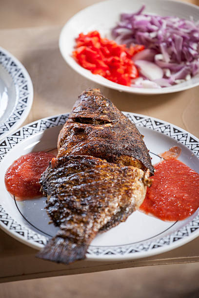 istock Baked tilapia served with red pepper sauce 494397113