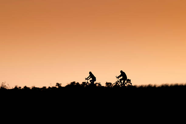 istock Silhouette of two riding bikers on sunset. 494397877