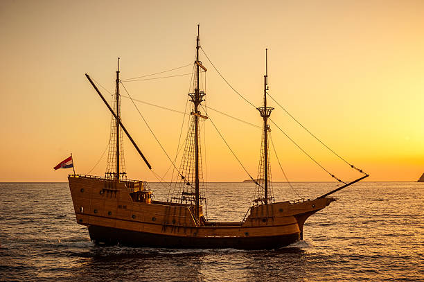 Medieval sailing ship in sunset stock photo
