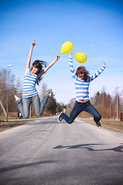 deux jeunes filles avec des ballons de sauter - striped women smiley face energy photos et images de collection