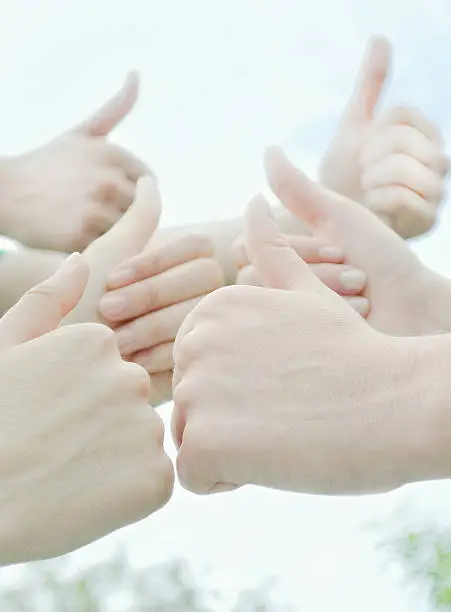 Photo of Close-up of hands giving thumbs up sign