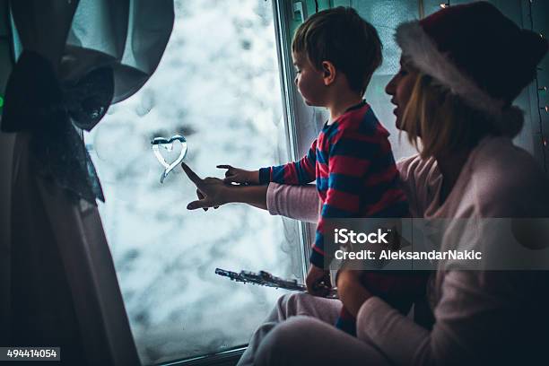 Christmas Eve By The Frosted Window Stock Photo - Download Image Now - Window, Christmas, Family