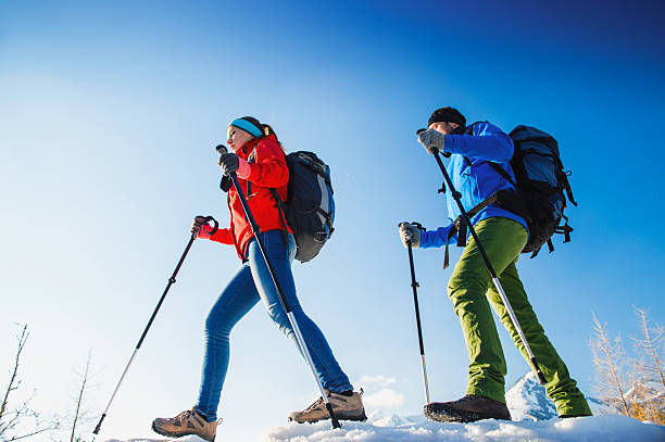 Beautiful young female hiker climbing up a mountain. It is winter.