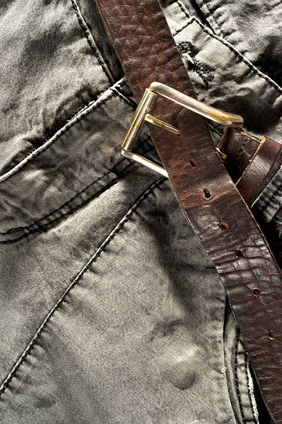 istock Leather brown belt on gray trousers 494414614