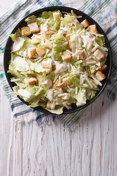 istock Traditional Caesar salad on a plate. vertical top view 494415576