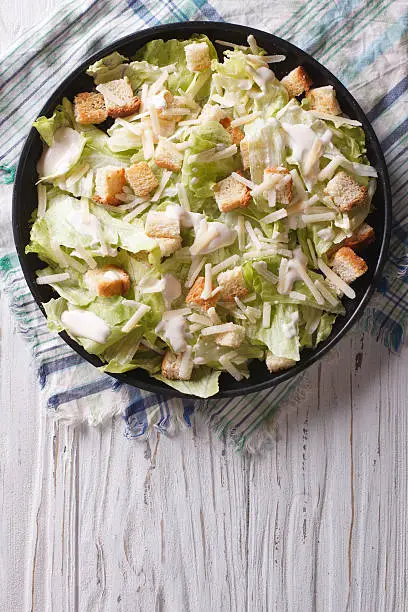 Photo of Traditional Caesar salad on a plate. vertical top view