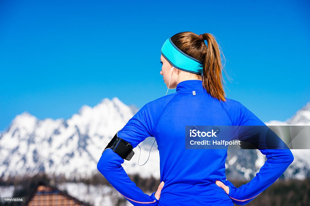 Woman running in mountains Young woman jogging outside in sunny winter mountains 2015 Stock Photo