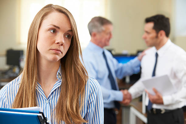Unhappy Businesswoman With Male Colleague Being Congratulated Passed over for promotion imbalance photos stock pictures, royalty-free photos & images