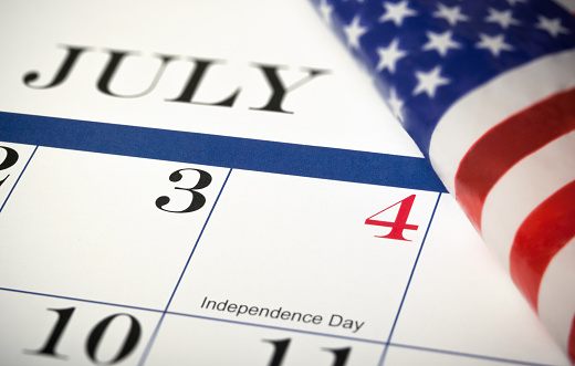 Close-up of a July calendar with part of an American flag, Shot with a shallow depth of field.