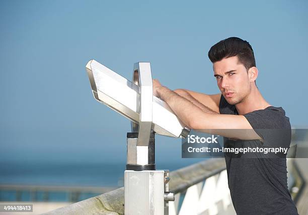 Attractive Man Leaning On Telescope On Tourism Pier Stock Photo - Download Image Now