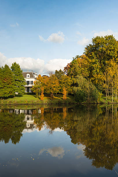 istock Large white country home at the river banks 494423588