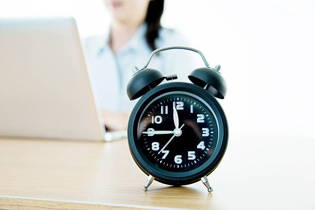 istock Businesswoman working on laptop with clock showing time 494423820