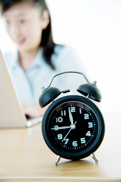 istock Businesswoman working on laptop with clock showing time 494423910