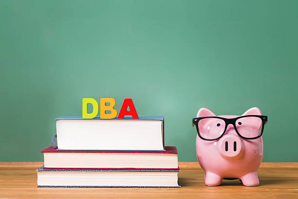 istock DBA theme with pink piggy bank 494424540