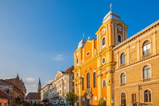 Photo of the Piarist Church and buildings in downtown Cluj Napoca, Romania at sunset.