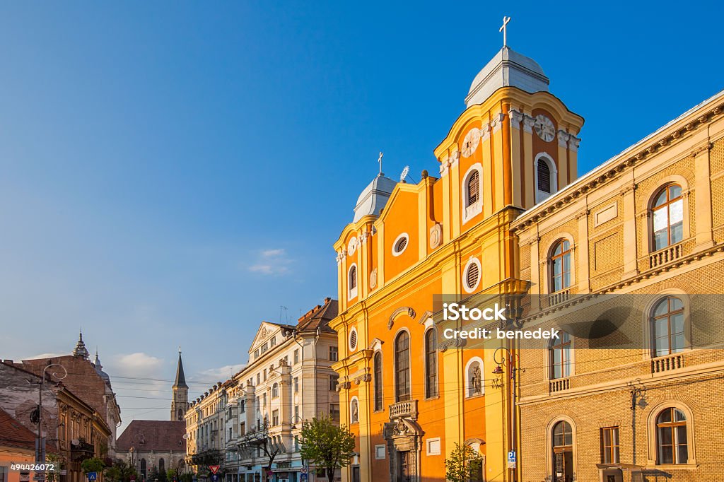 Downtown Cluj Romania Photo of the Piarist Church and buildings in downtown Cluj Napoca, Romania at sunset. Cluj Napoca - Romania Stock Photo