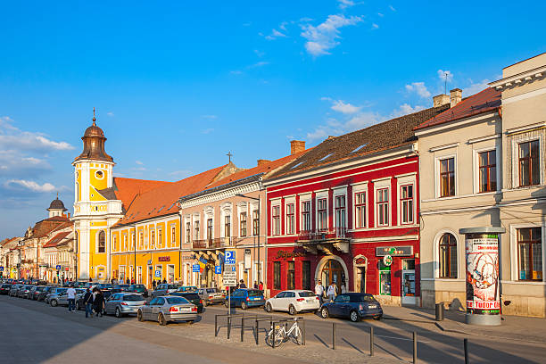 Cluj Napoca, Romania - April 25, 2010: Pedestrians walk past colorful facades on Bulevardul Eroilor in old town Cluj, Romania.